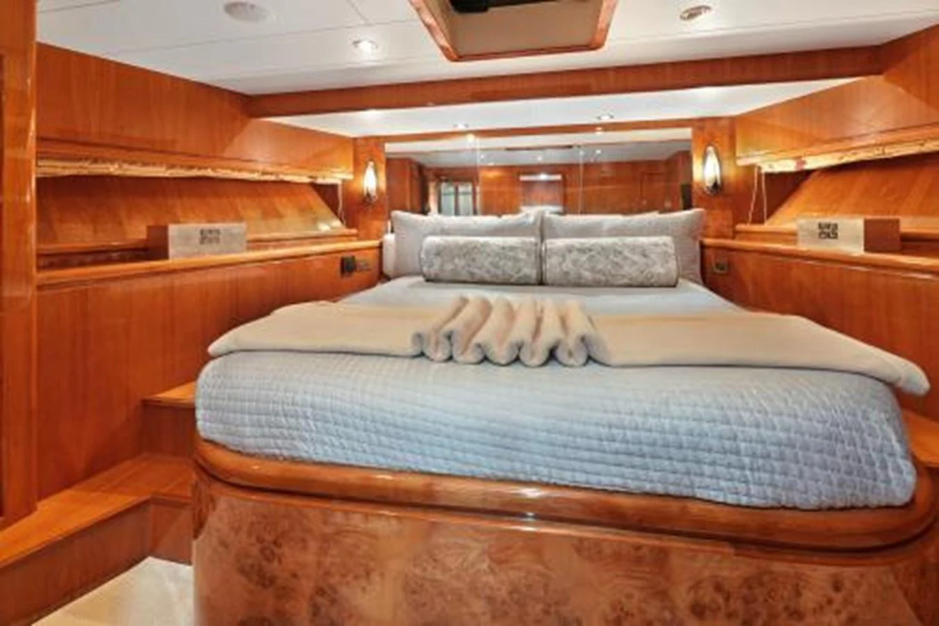 The master stateroom features a luxurious bed with plush bedding and elegant wood finishes. aboard SUE CAROLYN Yacht for Sale
