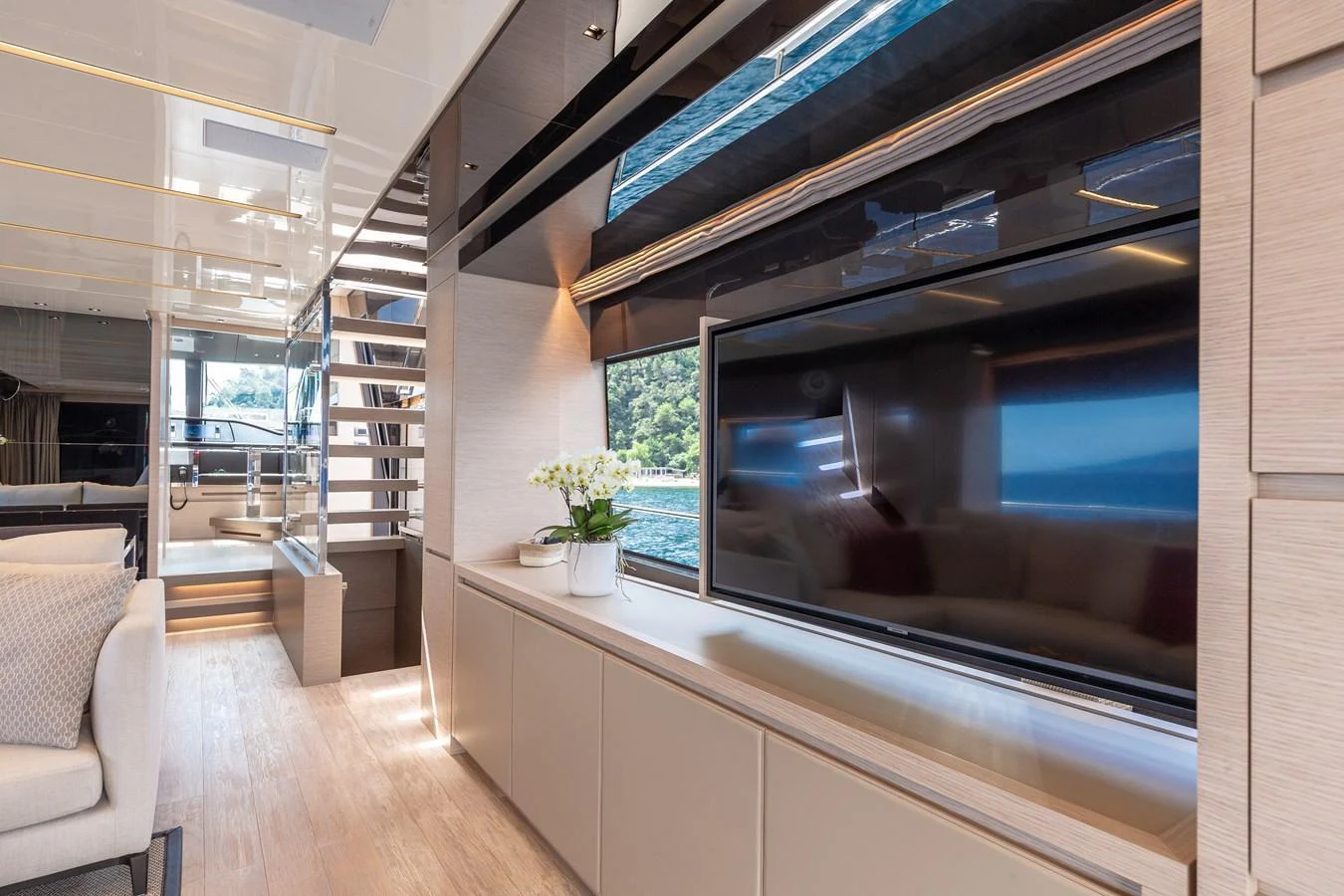 The yacht's interior features a modern entertainment area with a large flat-screen TV and stylish decor. aboard REGINE OF CANNES Yacht for Sale