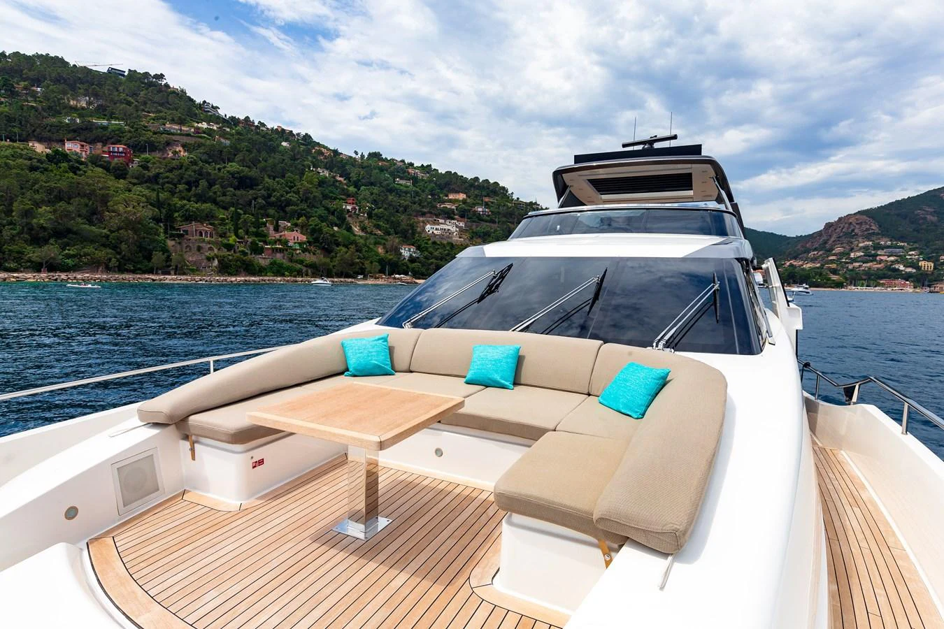 The yacht's foredeck features a spacious seating area with a wooden table, perfect for enjoying the scenic views. aboard REGINE OF CANNES Yacht for Sale