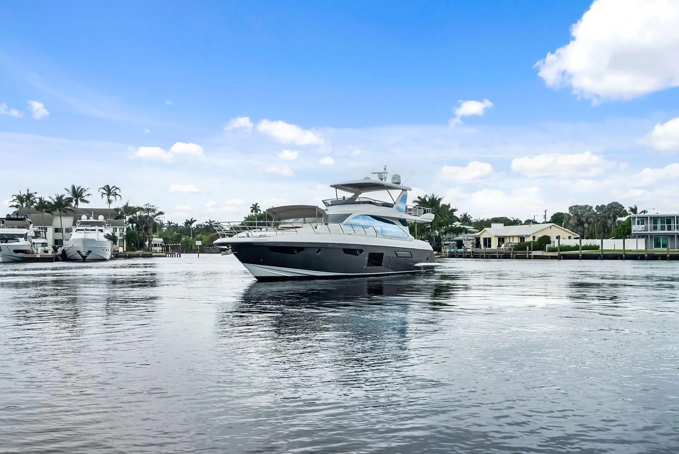 A sleek, modern yacht glides gracefully on calm waters under a bright blue sky. aboard CLASS DISMISSED Yacht for Sale