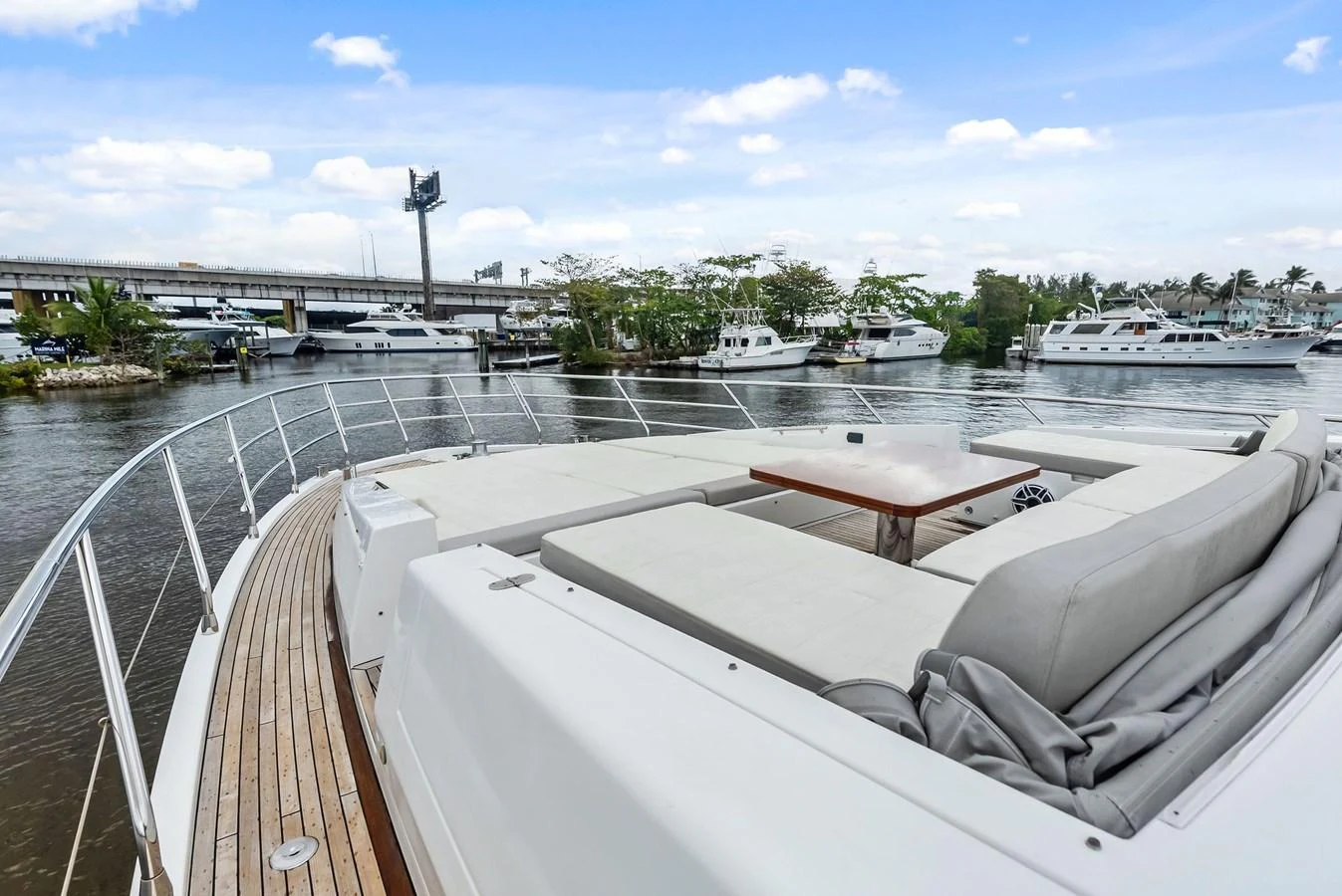 The foredeck features a spacious sunbathing area with plush seating and a central table, offering a perfect spot for relaxation. aboard CLASS DISMISSED Yacht for Sale