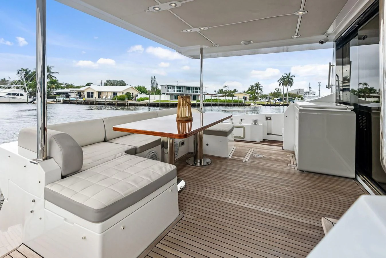 The aft deck features a spacious seating area with a wooden table, perfect for alfresco dining and relaxation. aboard CLASS DISMISSED Yacht for Sale