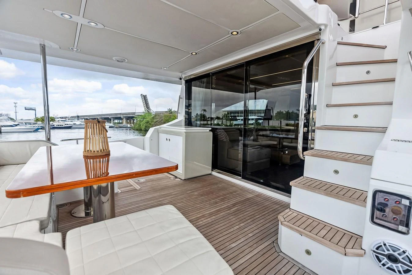 The aft deck features a comfortable seating area with a wooden table and easy access to the interior through sliding glass doors. aboard CLASS DISMISSED Yacht for Sale