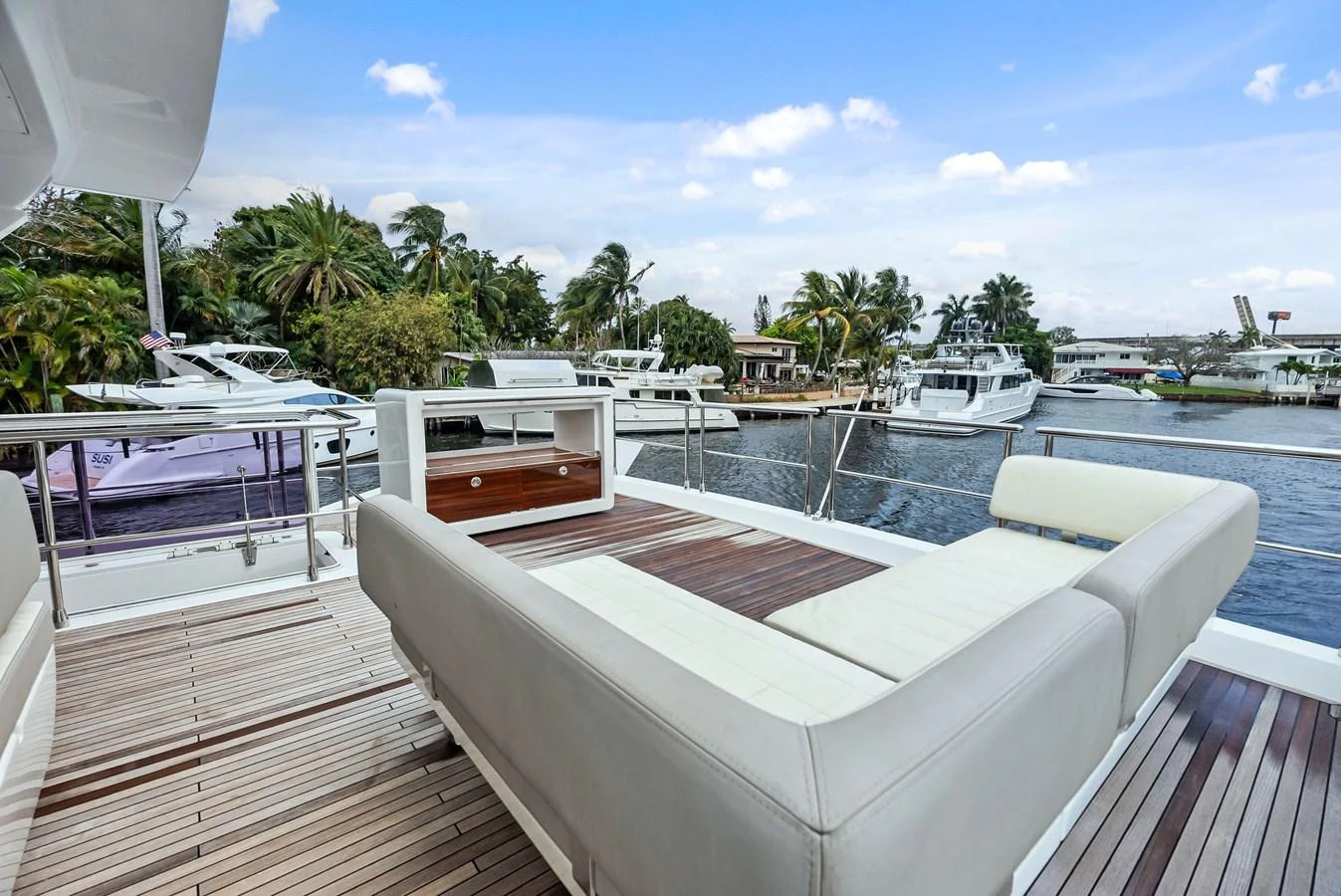 The aft deck features a luxurious lounging area with a scenic view of the marina. aboard CLASS DISMISSED Yacht for Sale