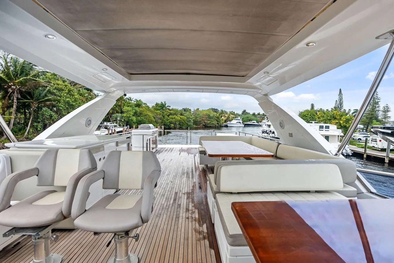 The flybridge offers a spacious and luxurious outdoor seating area with a view of the surrounding marina. aboard CLASS DISMISSED Yacht for Sale