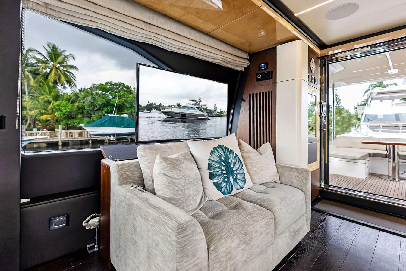 The salon features a comfortable sofa with a view of the water through large windows. aboard CLASS DISMISSED Yacht for Sale