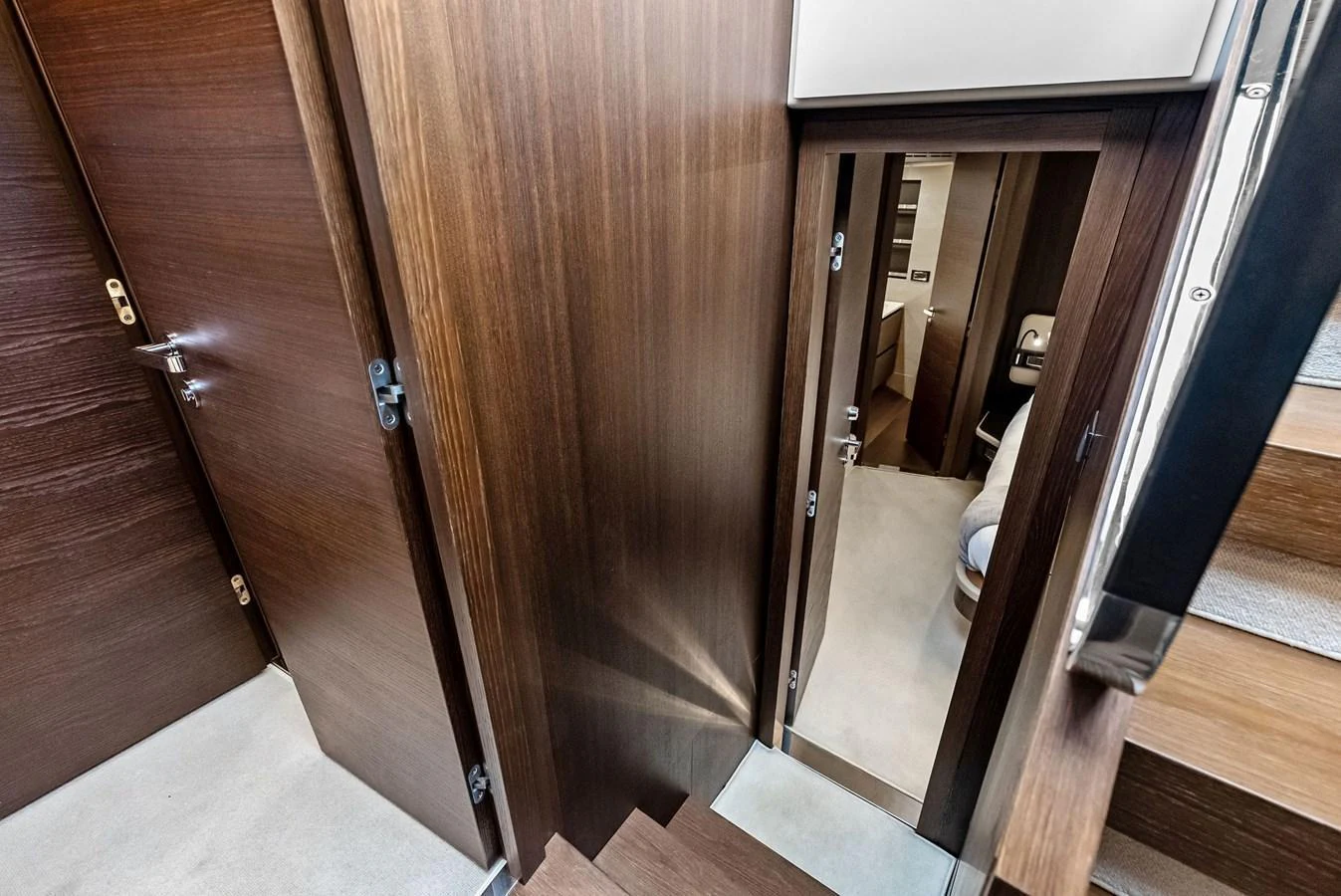 A view of the yacht's interior hallway with wooden paneling and doors leading to various rooms. aboard CLASS DISMISSED Yacht for Sale