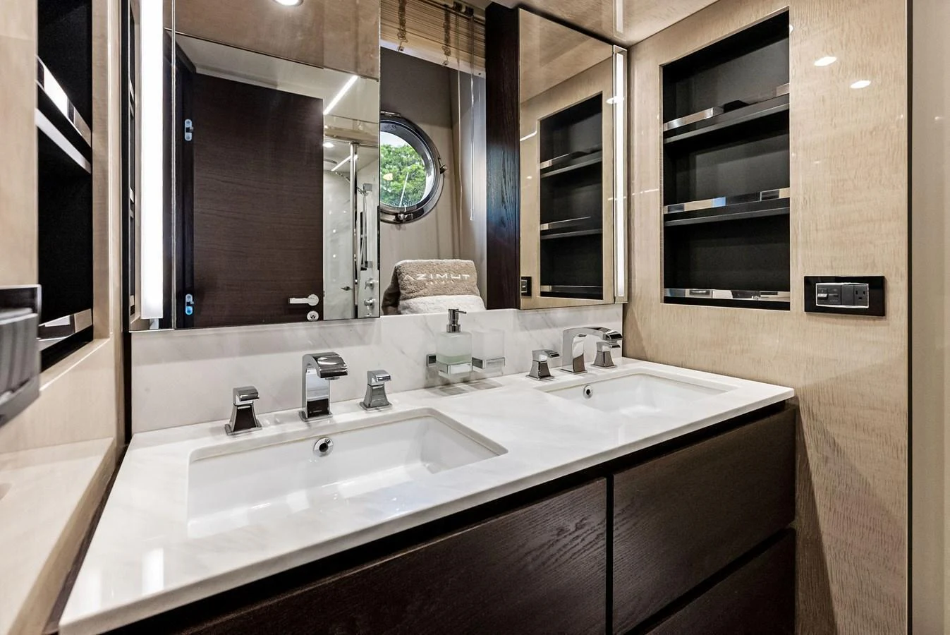 The yacht's bathroom features a sleek double sink vanity with modern fixtures and ample storage. aboard CLASS DISMISSED Yacht for Sale