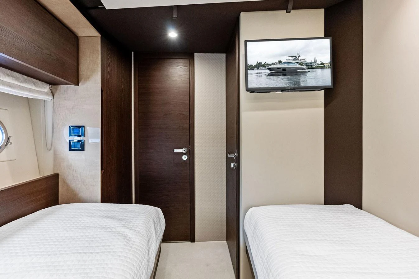 The guest cabin features twin beds and a wall-mounted TV for a comfortable stay. aboard CLASS DISMISSED Yacht for Sale