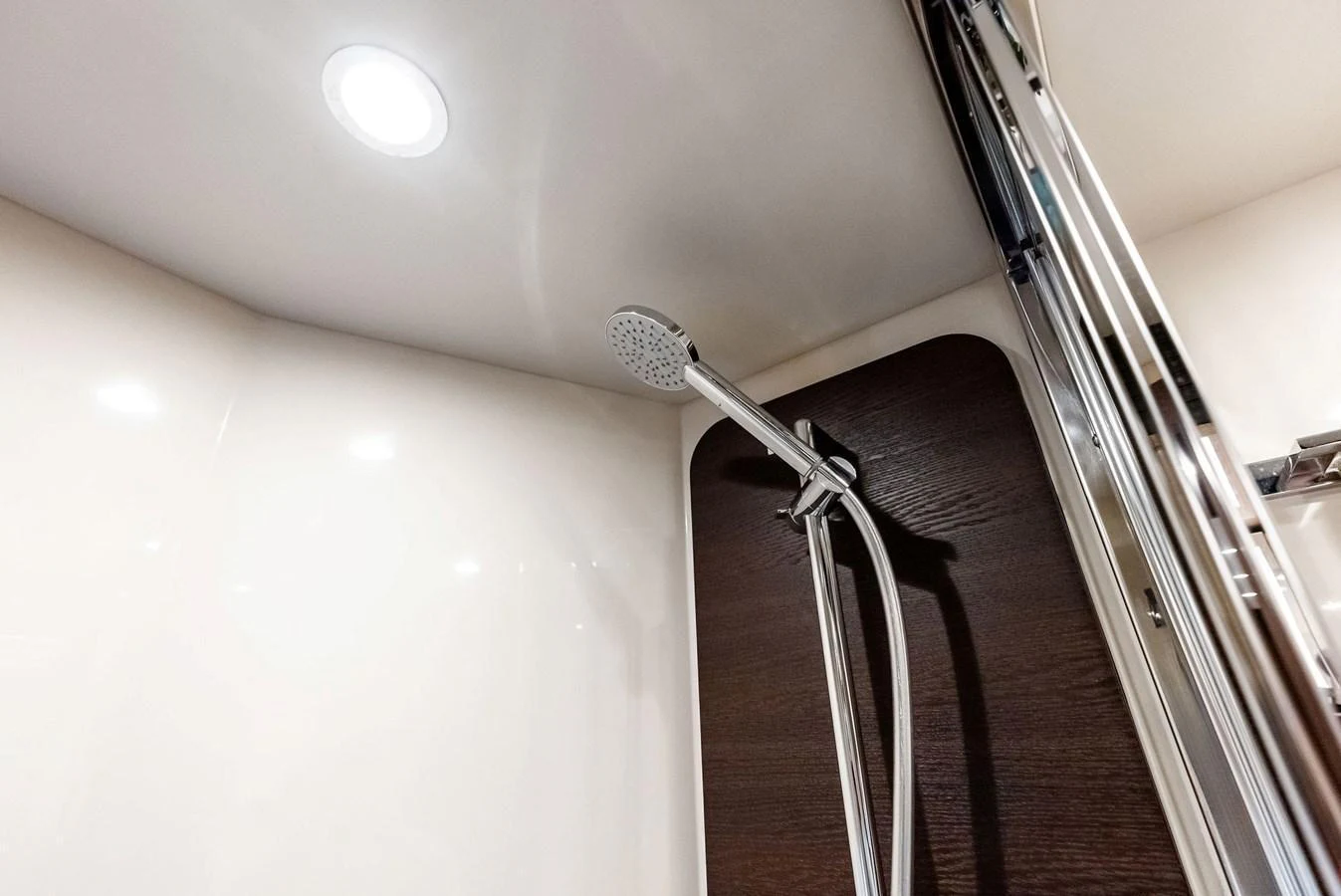 A sleek and modern shower area with a chrome showerhead and elegant finishes. aboard CLASS DISMISSED Yacht for Sale