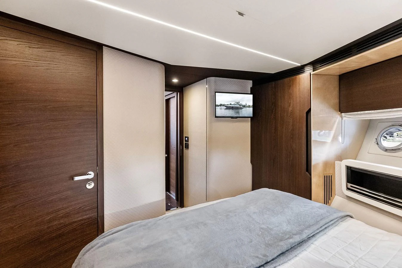 A cozy stateroom featuring a plush bed, wood paneling, and a flat-screen TV. aboard CLASS DISMISSED Yacht for Sale