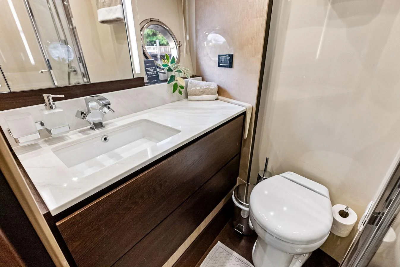 A modern yacht bathroom featuring a sleek sink and a compact toilet. aboard CLASS DISMISSED Yacht for Sale