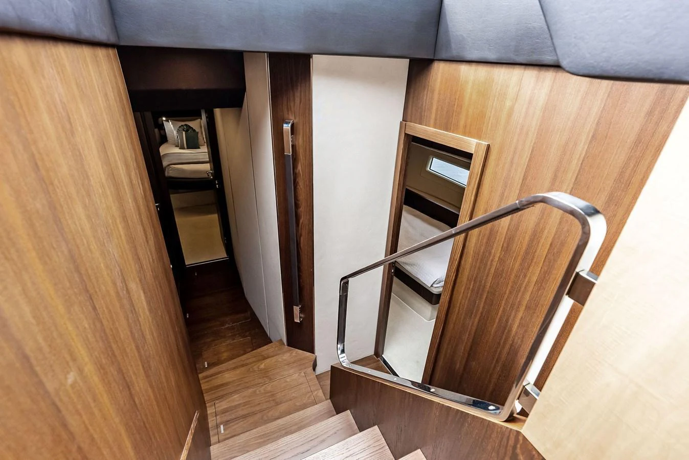 A sleek wooden staircase leads to the lower deck, showcasing modern design and craftsmanship. aboard CLASS DISMISSED Yacht for Sale