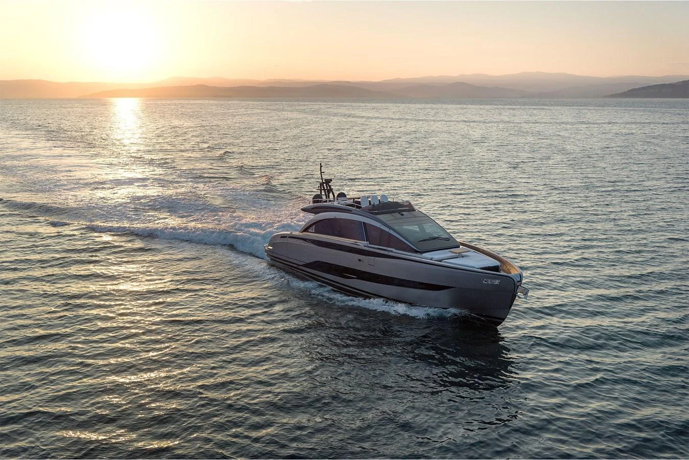 A sleek yacht cruises through calm waters at sunset, showcasing its elegant design. aboard GTX70 Yacht for Sale