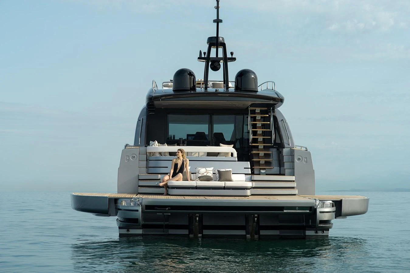 A luxurious yacht's aft deck featuring a lounging area with a serene ocean backdrop. aboard GTX70 Yacht for Sale