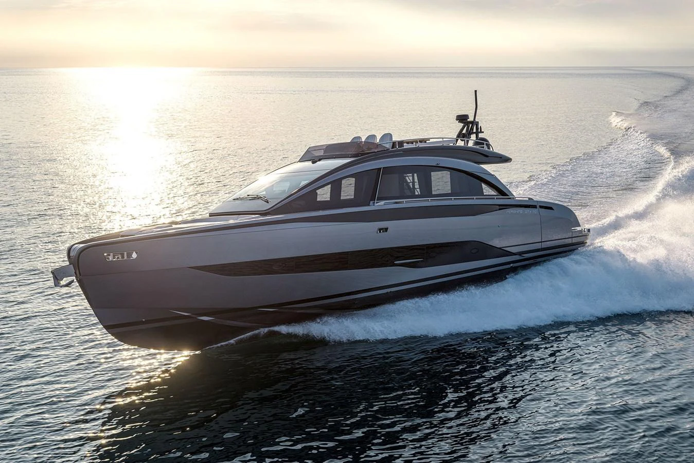 A sleek and modern yacht glides swiftly across the water at sunset. aboard GTX70 Yacht for Sale