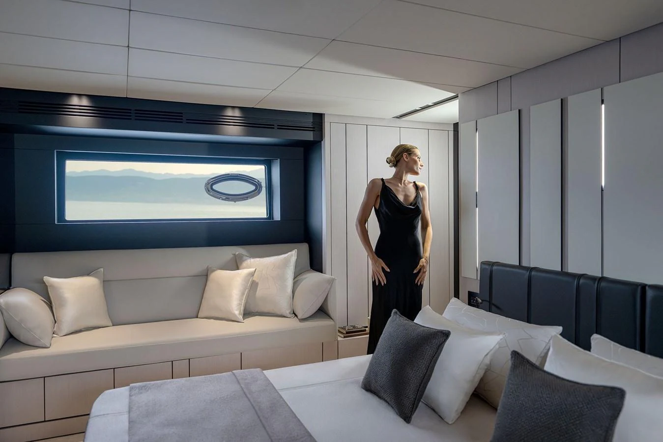 A luxurious stateroom featuring a comfortable bed, a cozy seating area, and a large window with a scenic view. aboard GTX70 Yacht for Sale