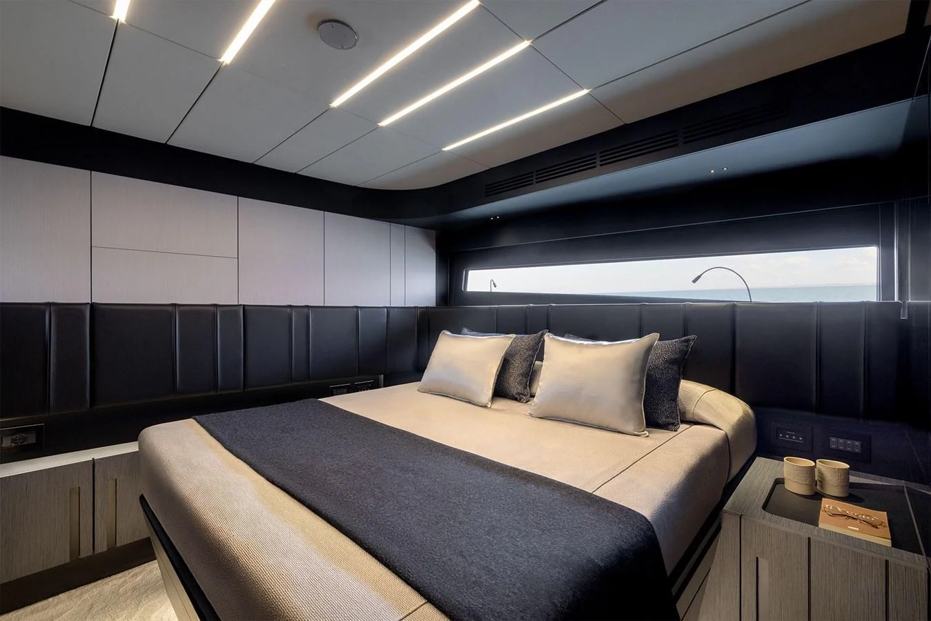 A luxurious stateroom featuring a large bed with elegant bedding and modern lighting. aboard GTX70 Yacht for Sale