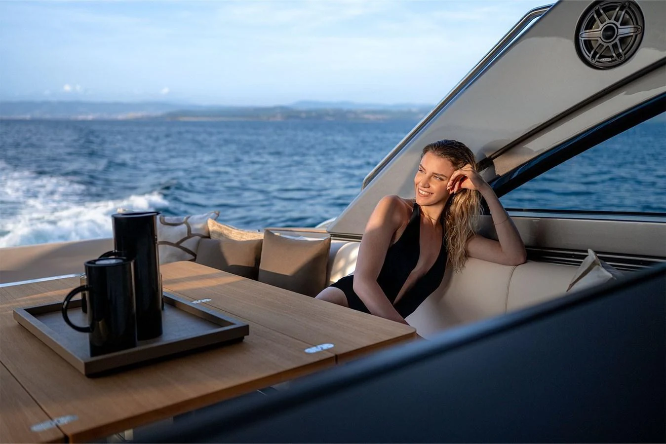 A serene aft deck area with a stylish seating arrangement and a view of the open sea. aboard GTX70 Yacht for Sale