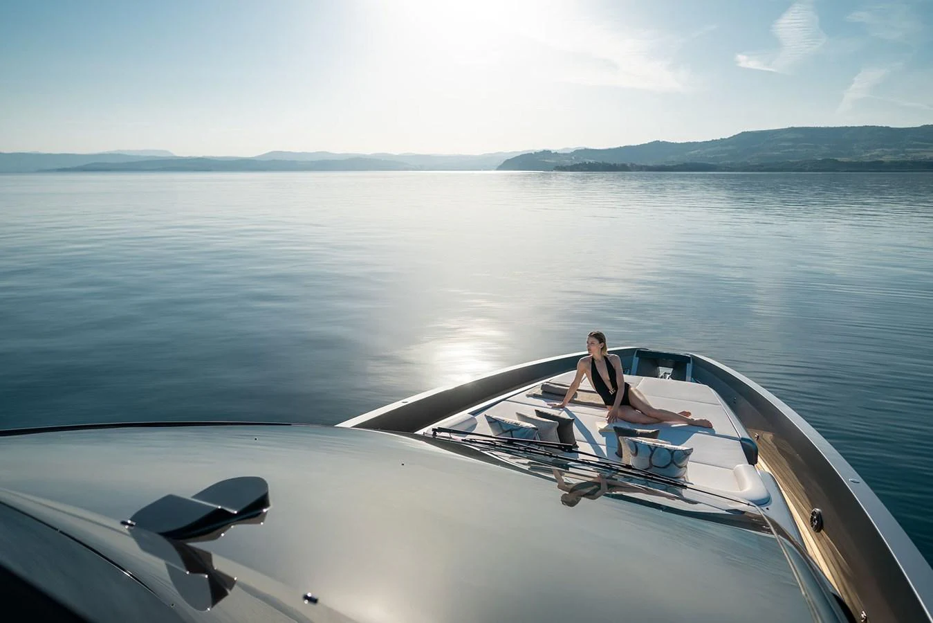 A serene view of the yacht's foredeck with a person relaxing under the sun. aboard GTX70 Yacht for Sale