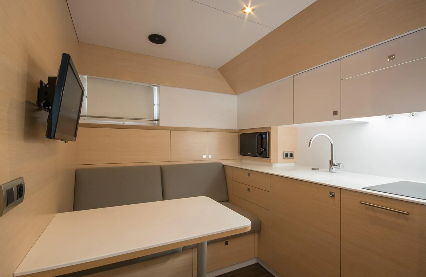 The galley features modern cabinetry, a cozy dining nook, and sleek appliances. aboard 20 YXT Yacht for Sale