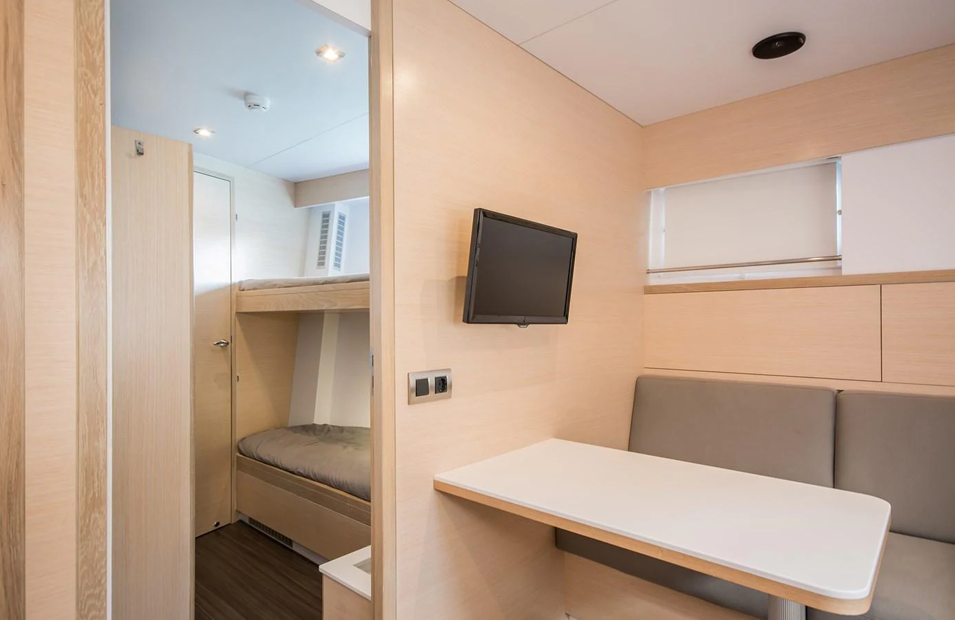 The image showcases a cozy cabin area with a bunk bed, a small table, and a wall-mounted television. aboard 20 YXT Yacht for Sale