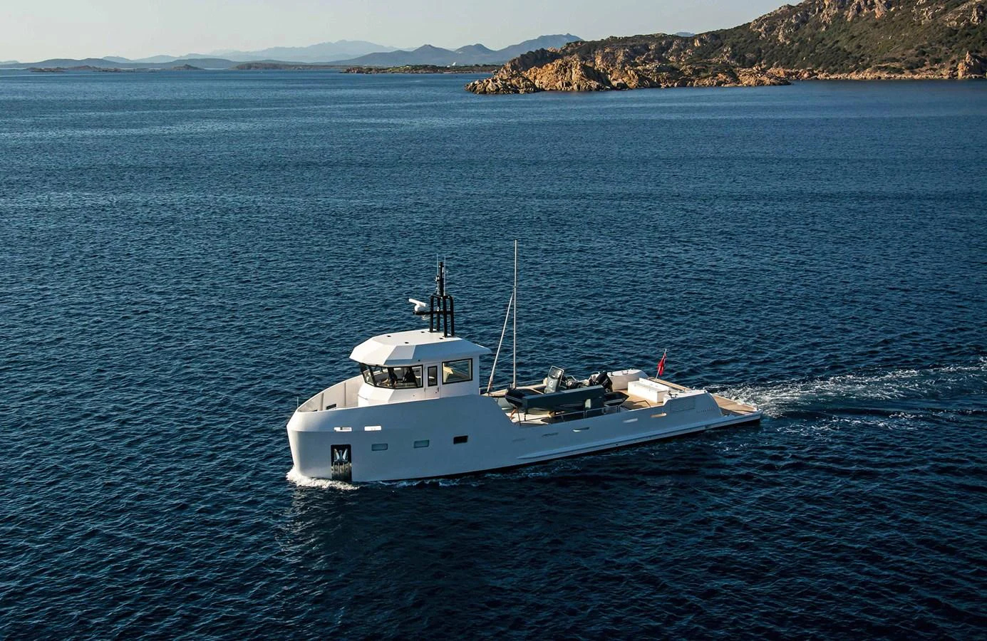 A sleek yacht cruises through serene waters with a picturesque coastline in the background. aboard 20 YXT Yacht for Sale