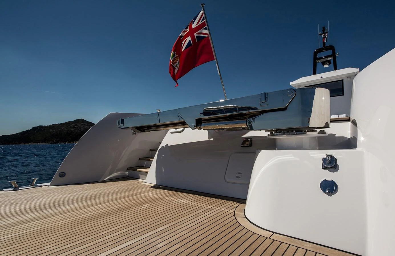 The aft deck of the yacht features sleek lines and a polished finish, complemented by a prominent flag. aboard 20 YXT Yacht for Sale