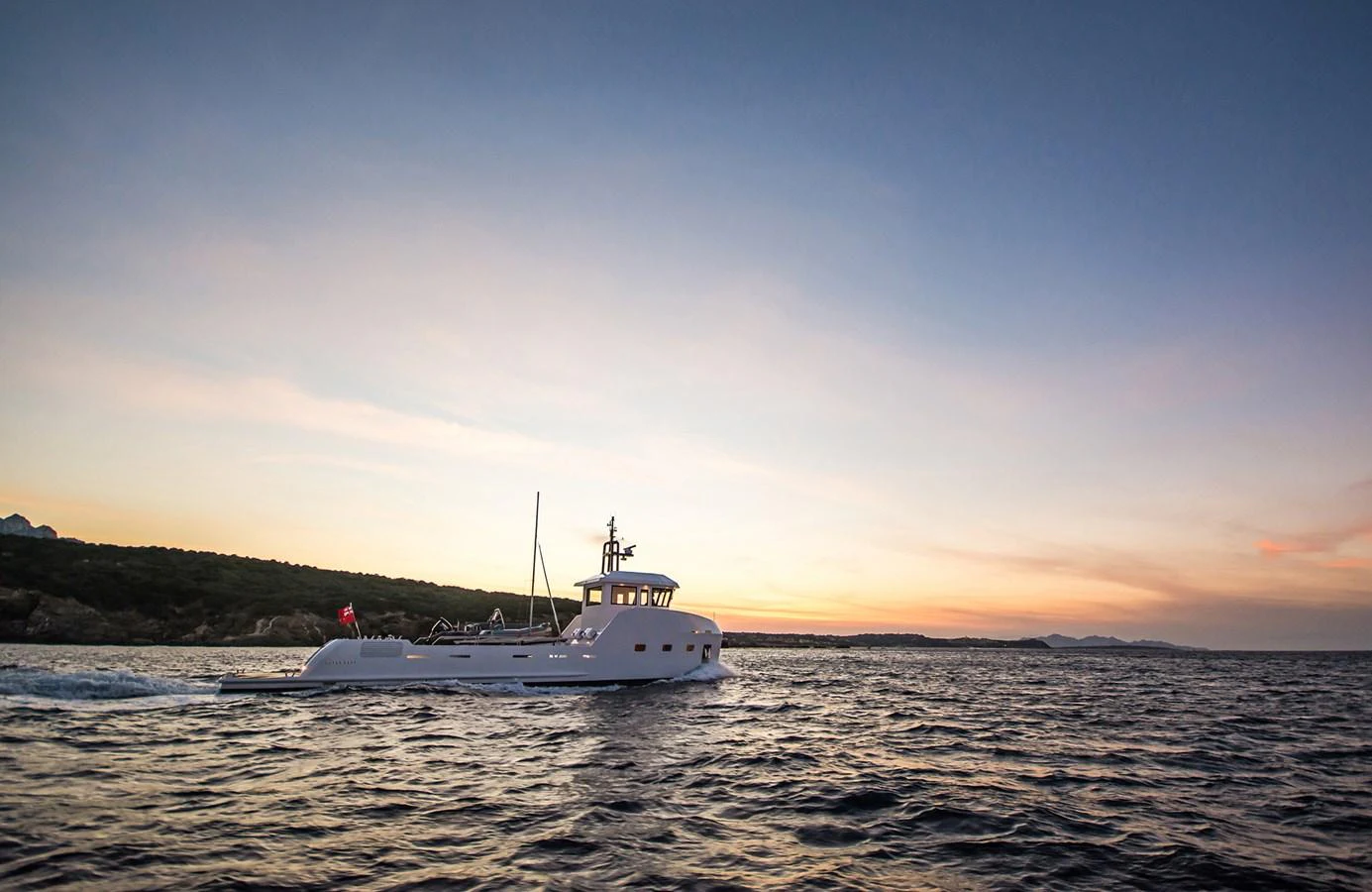 A sleek yacht cruises through calm waters against a stunning sunset backdrop. aboard 20 YXT Yacht for Sale