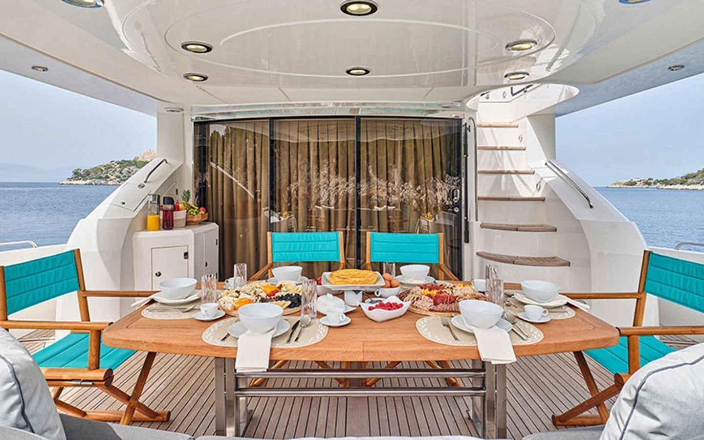 The aft deck features a beautifully set dining table with a view of the sea, perfect for alfresco meals. aboard M FIVE Yacht for Sale