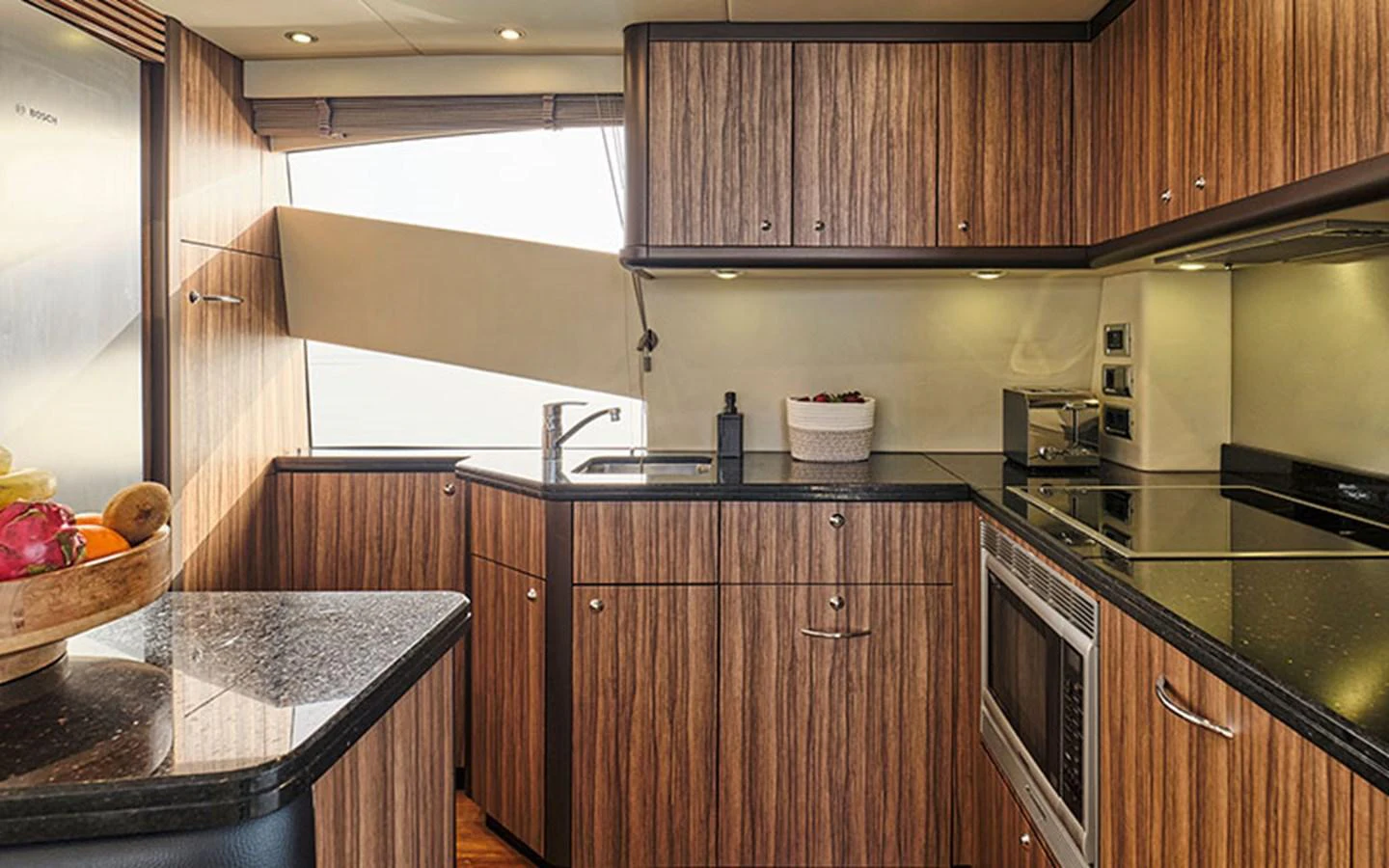 The yacht's galley features modern appliances and sleek wooden cabinetry, creating a stylish and functional space. aboard M FIVE Yacht for Sale