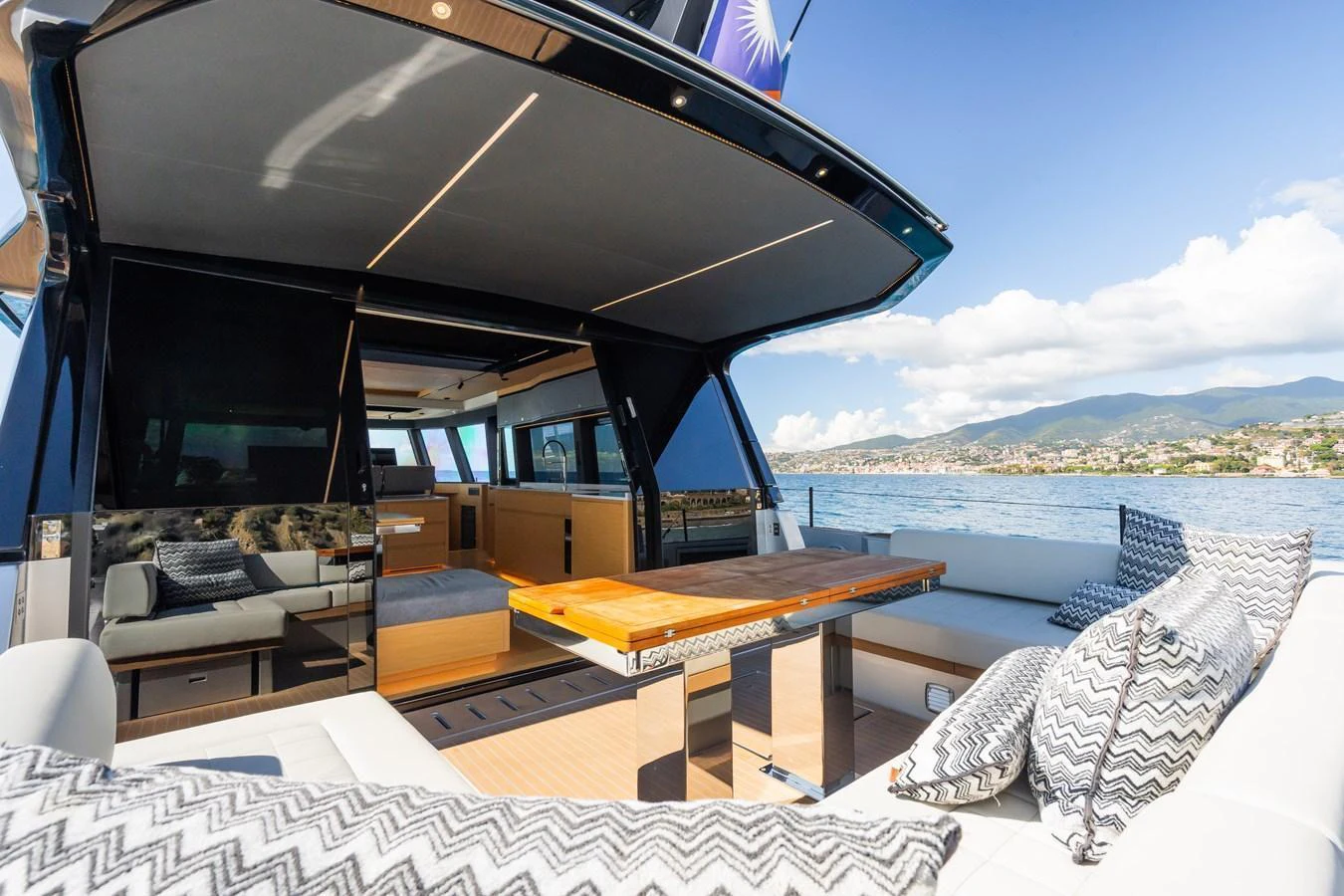 The aft deck offers a comfortable seating area with a stylish table and scenic views. aboard SIMON Yacht for Sale