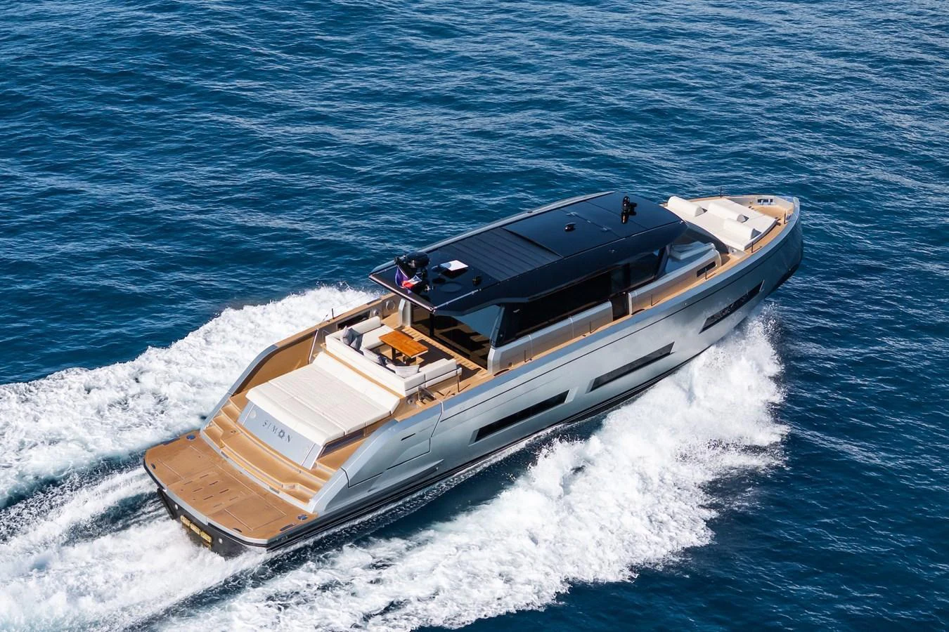 A sleek and modern yacht cruising through the open water, showcasing its elegant design and spacious deck. aboard SIMON Yacht for Sale
