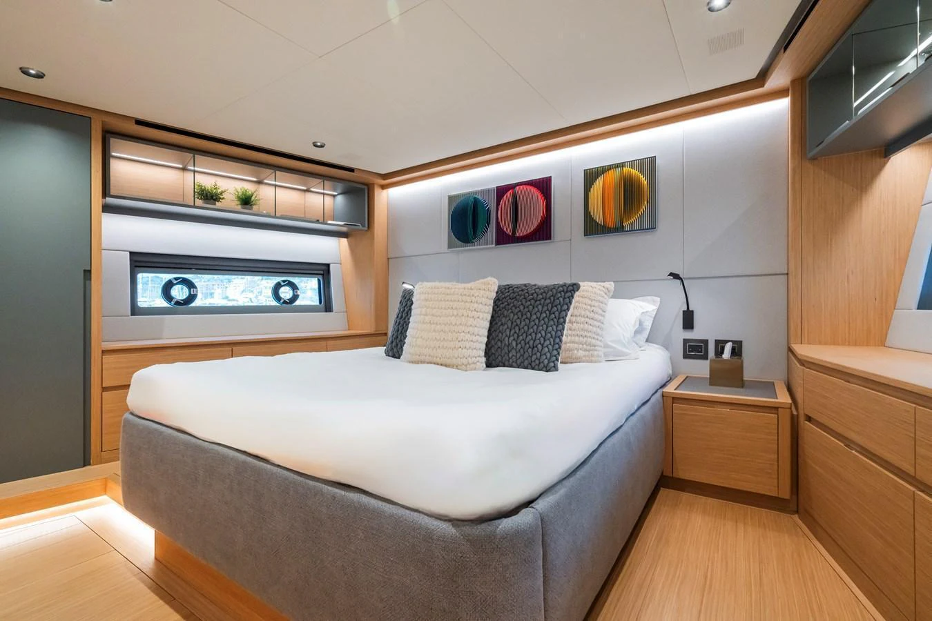The stateroom features a plush bed with modern decor and ample natural light. aboard SIMON Yacht for Sale