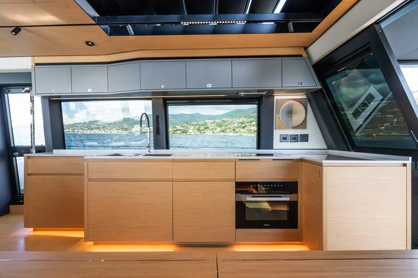 The modern galley features sleek cabinetry and expansive windows with a stunning view. aboard SIMON Yacht for Sale