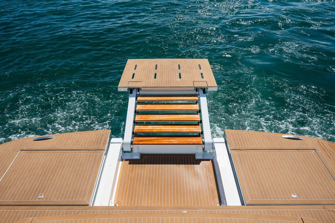 The yacht features a well-designed swim platform with wooden steps leading into the water. aboard SIMON Yacht for Sale