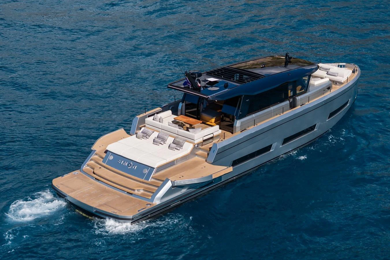 A sleek, modern yacht cruising on clear blue waters with ample deck space for relaxation. aboard SIMON Yacht for Sale
