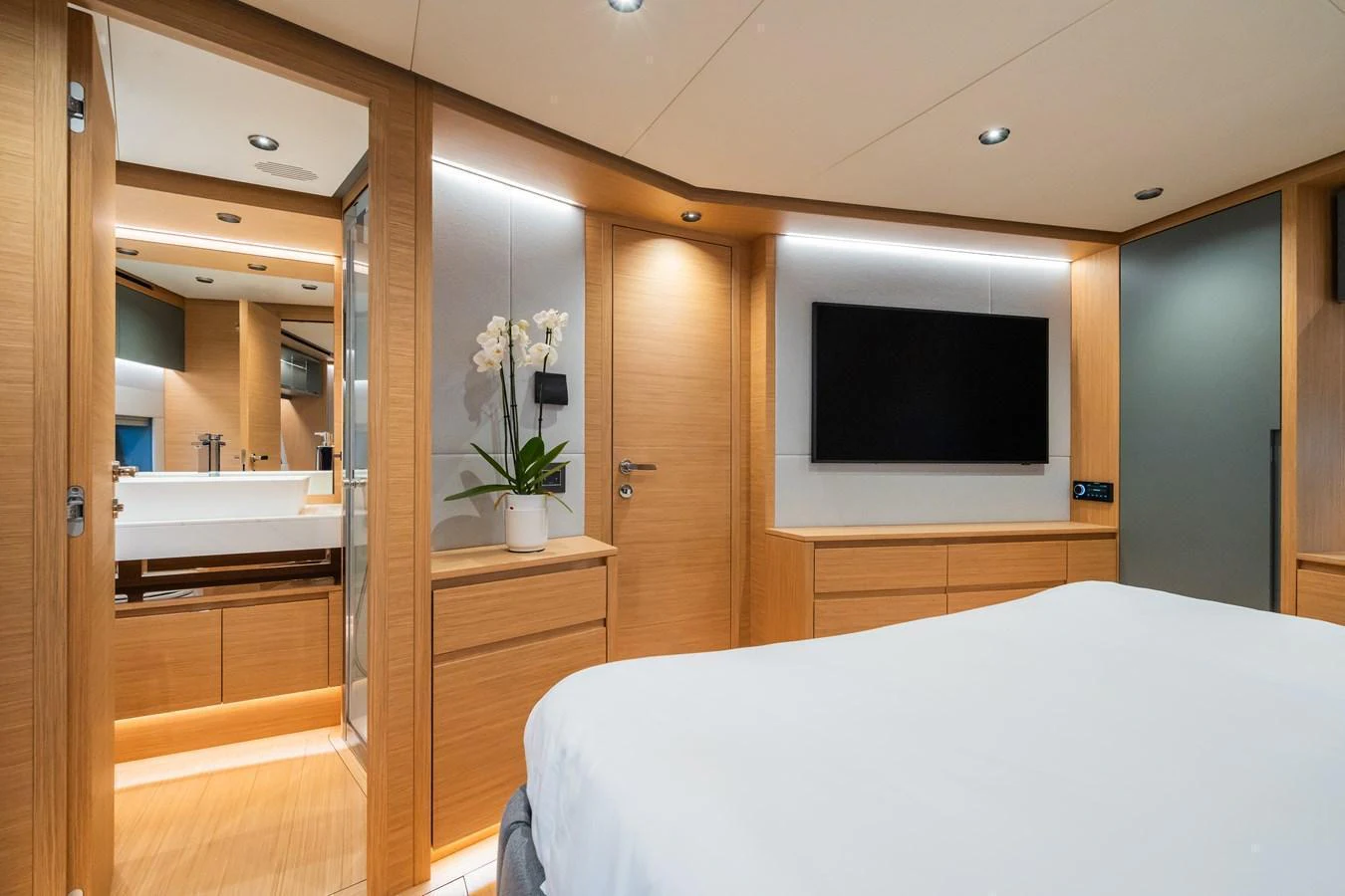 This stateroom features modern wood finishes, a flat-screen TV, and an ensuite bathroom. aboard SIMON Yacht for Sale
