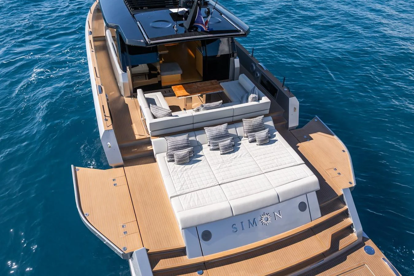 The yacht's aft deck features a spacious lounging area with plush seating and sun pads, perfect for relaxation. aboard SIMON Yacht for Sale