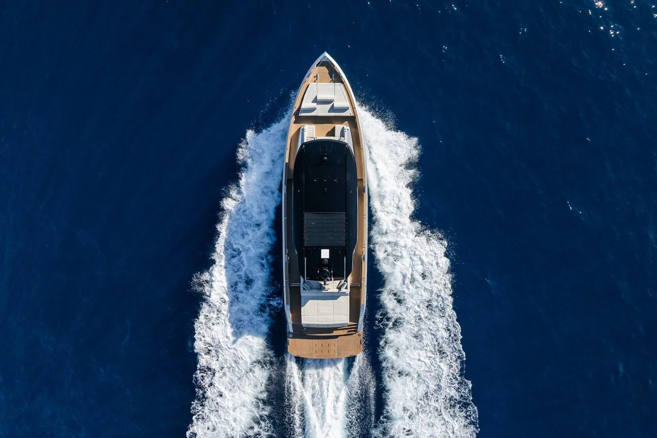 A sleek yacht cruises through deep blue waters, leaving a trail of white wake behind. aboard SIMON Yacht for Sale