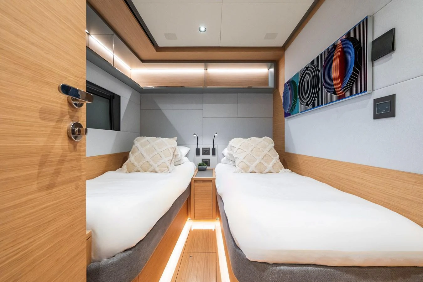 The twin stateroom features modern decor with comfortable twin beds and ambient lighting. aboard SIMON Yacht for Sale