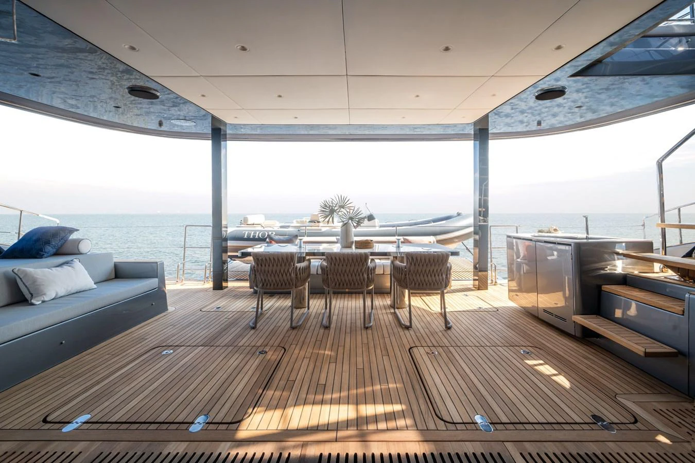 The aft deck offers a spacious and inviting area with comfortable seating and dining arrangements, perfect for enjoying the sea view. aboard THOR Yacht for Sale