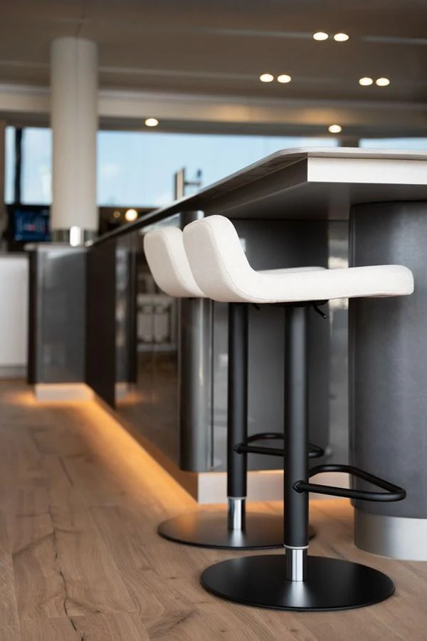 The modern galley features sleek bar stools and ambient lighting, creating a stylish and inviting space. aboard THOR Yacht for Sale