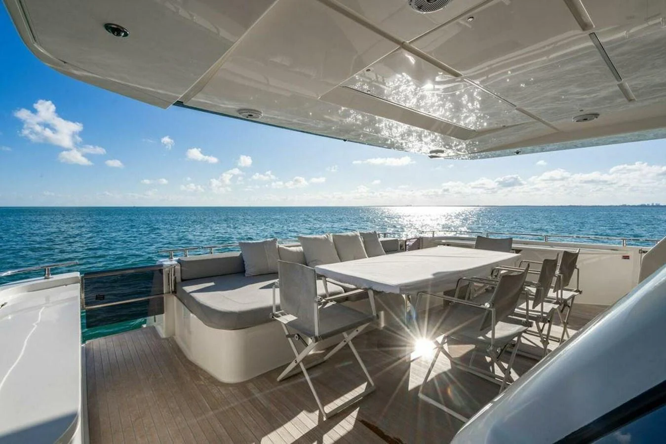 a deck with chairs and tables on it by the ocean aboard 85 FERRETTI Yacht for Sale