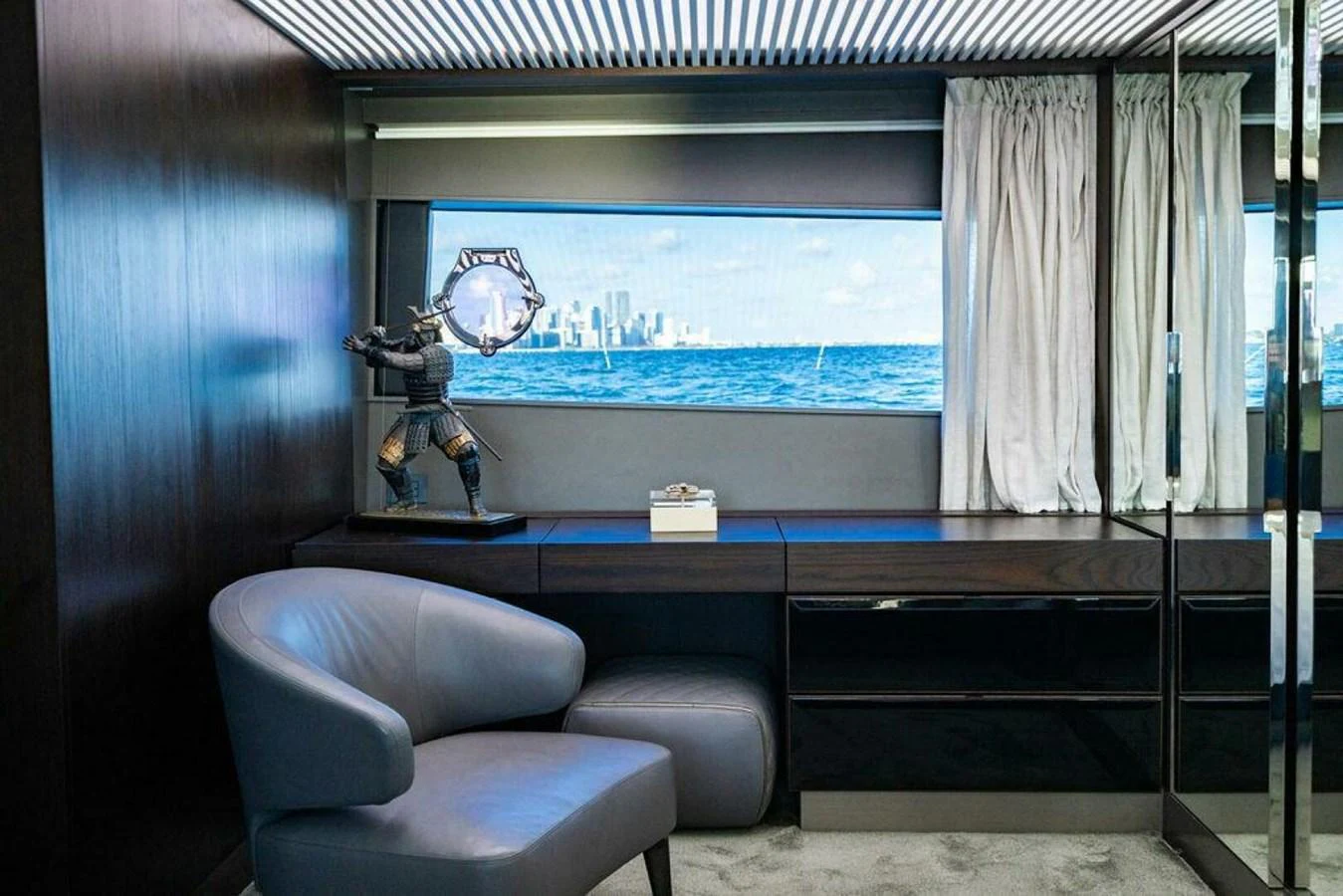 a room with a window and a desk with a chair and a view of the city aboard 85 FERRETTI Yacht for Sale