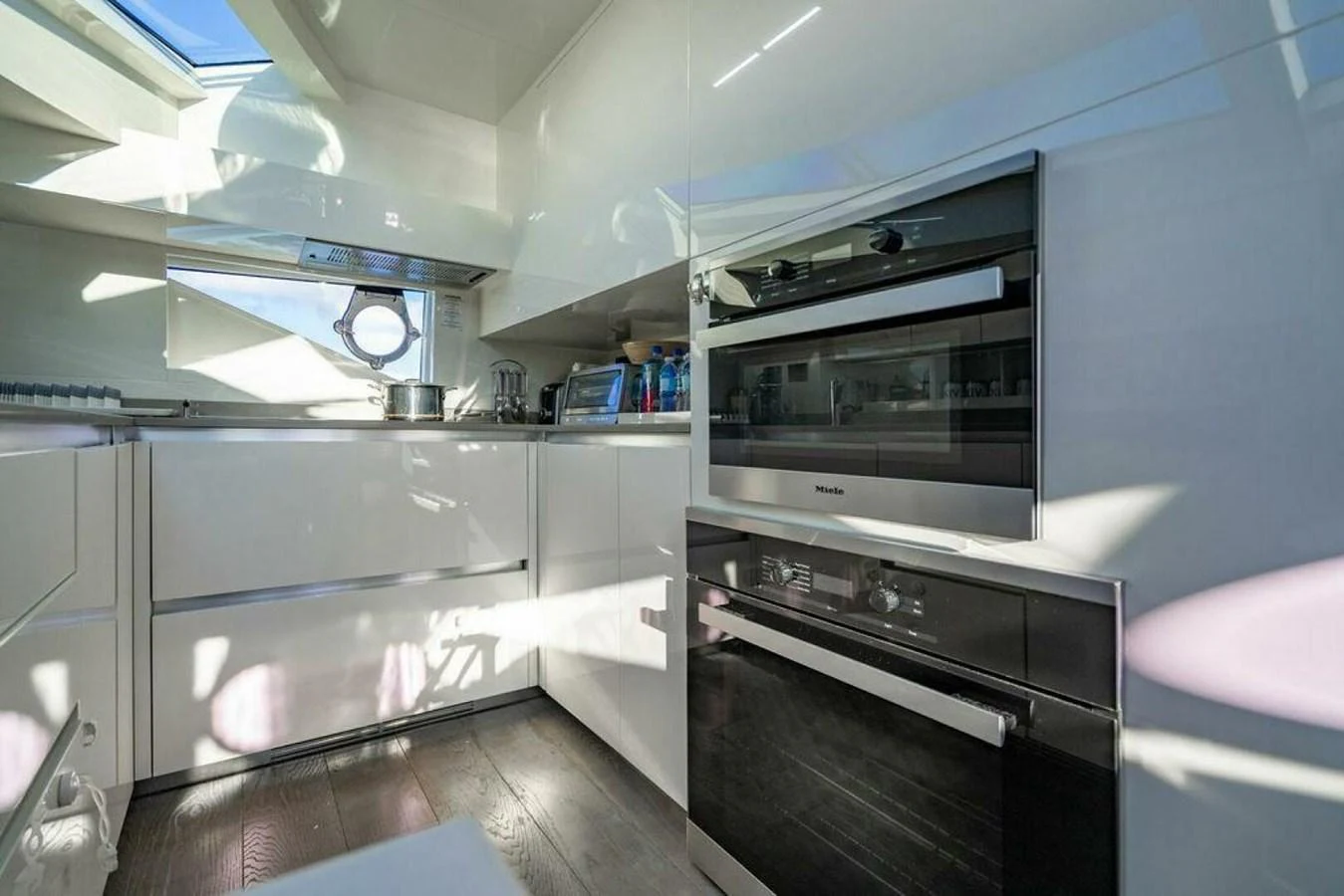 a kitchen with white cabinets aboard 85 FERRETTI Yacht for Sale