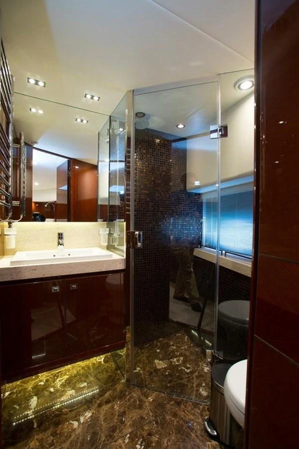 The yacht's bathroom features a sleek design with a glass shower and elegant finishes. aboard RAINBOW Yacht for Sale