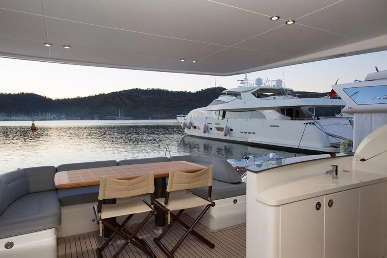 The aft deck offers a serene setting with comfortable seating and a dining area overlooking the water. aboard RAINBOW Yacht for Sale