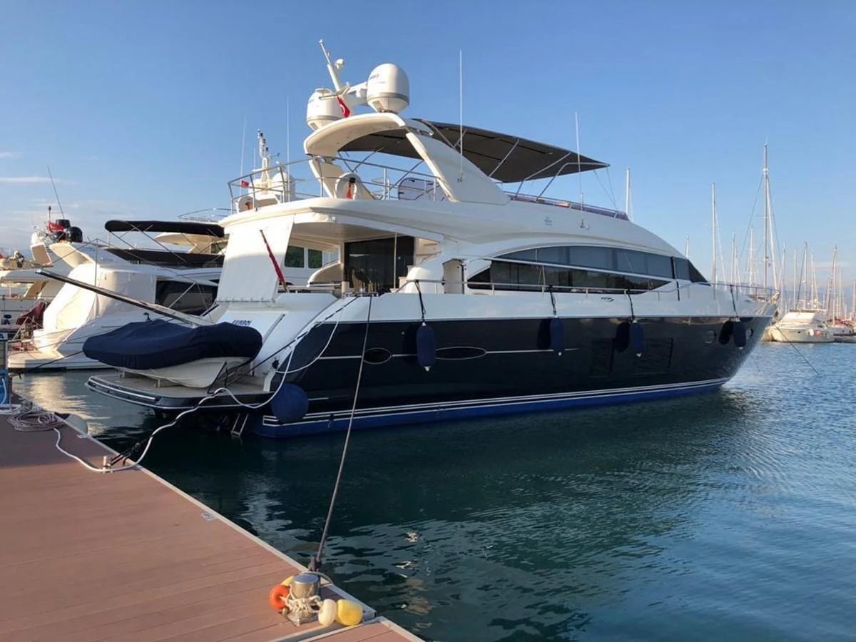 A sleek and modern yacht is docked at a marina, showcasing its elegant design and spacious decks. aboard RAINBOW Yacht for Sale