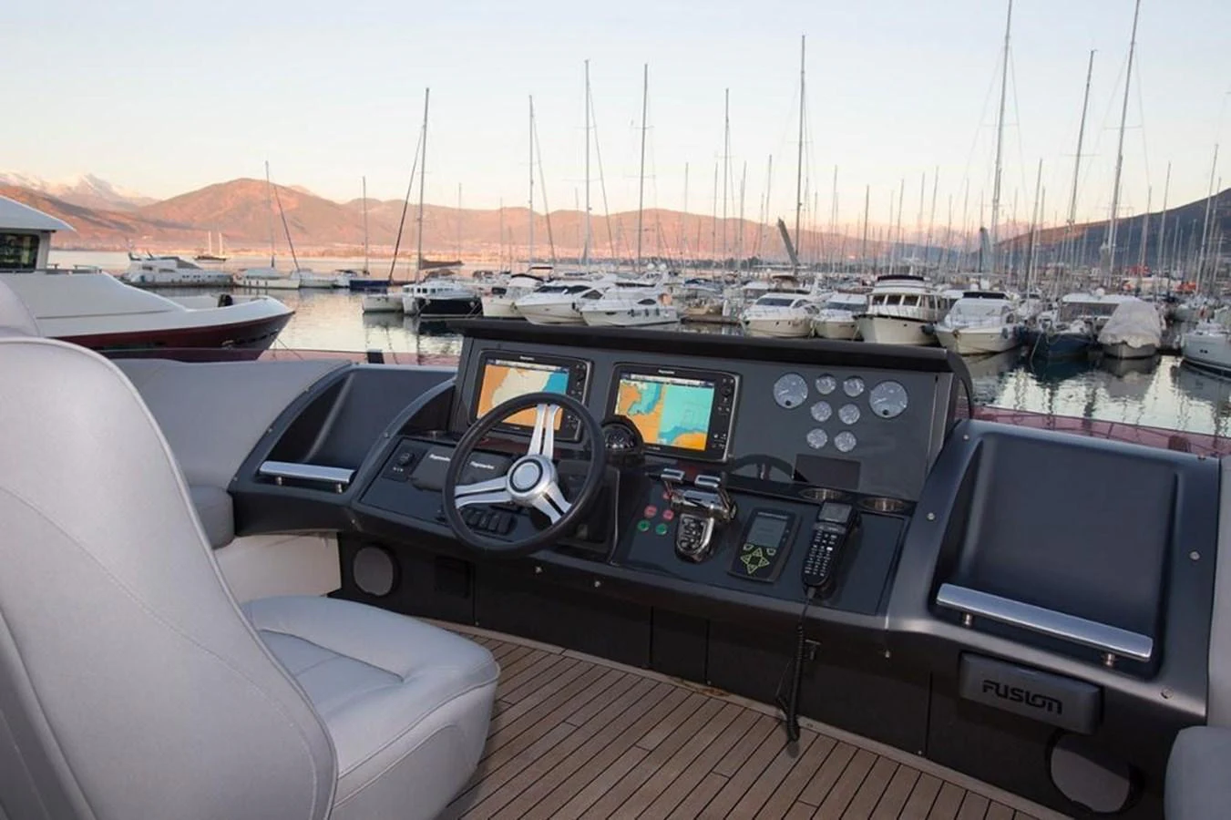 The helm station offers a commanding view of the marina, equipped with advanced navigation systems and comfortable seating. aboard RAINBOW Yacht for Sale